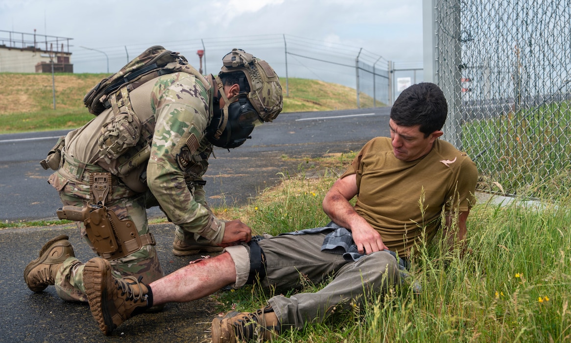 A U.S. Air Force member assists a simulated causality.