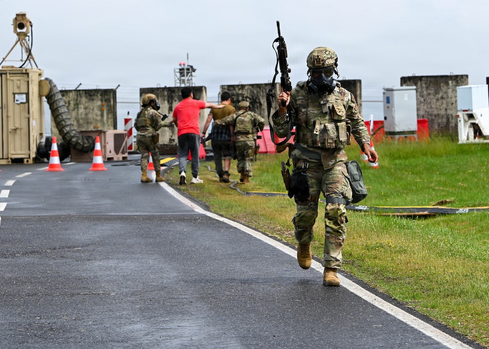 A U.S. Air Force member runs while holding a weapon.