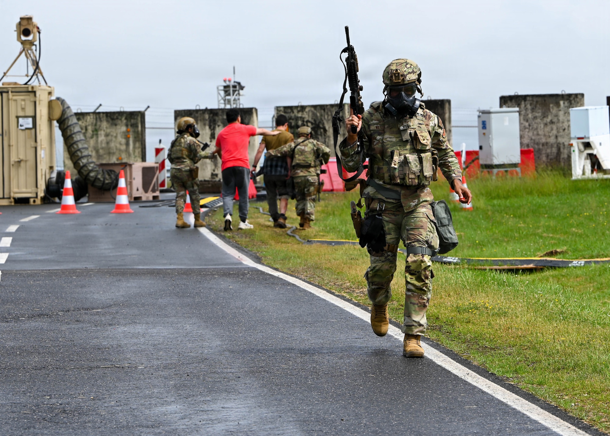 A U.S. Air Force member runs while holding a weapon.