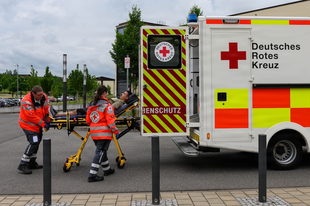 Emergency personnel roll a stretcher in an ambulance.