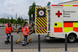 Emergency personnel roll a stretcher in an ambulance.