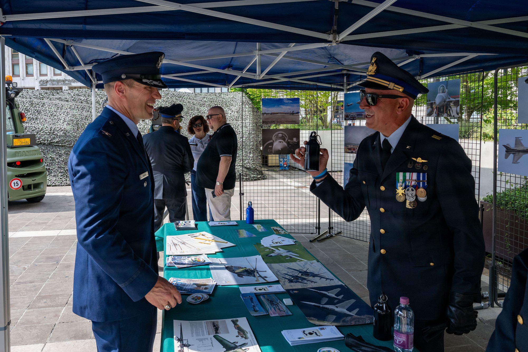 Two men in military uniform interact with each other