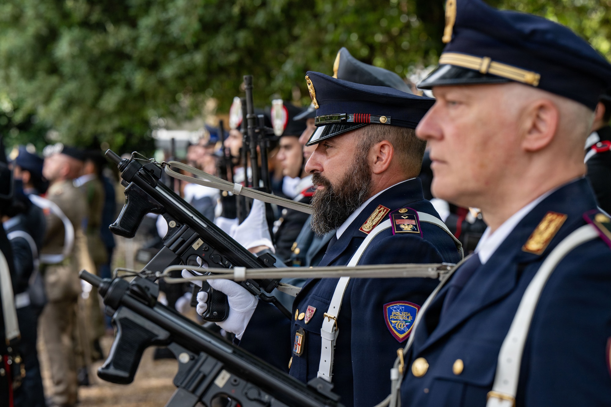 Men in police uniforms stand together with firearms during a ceremony