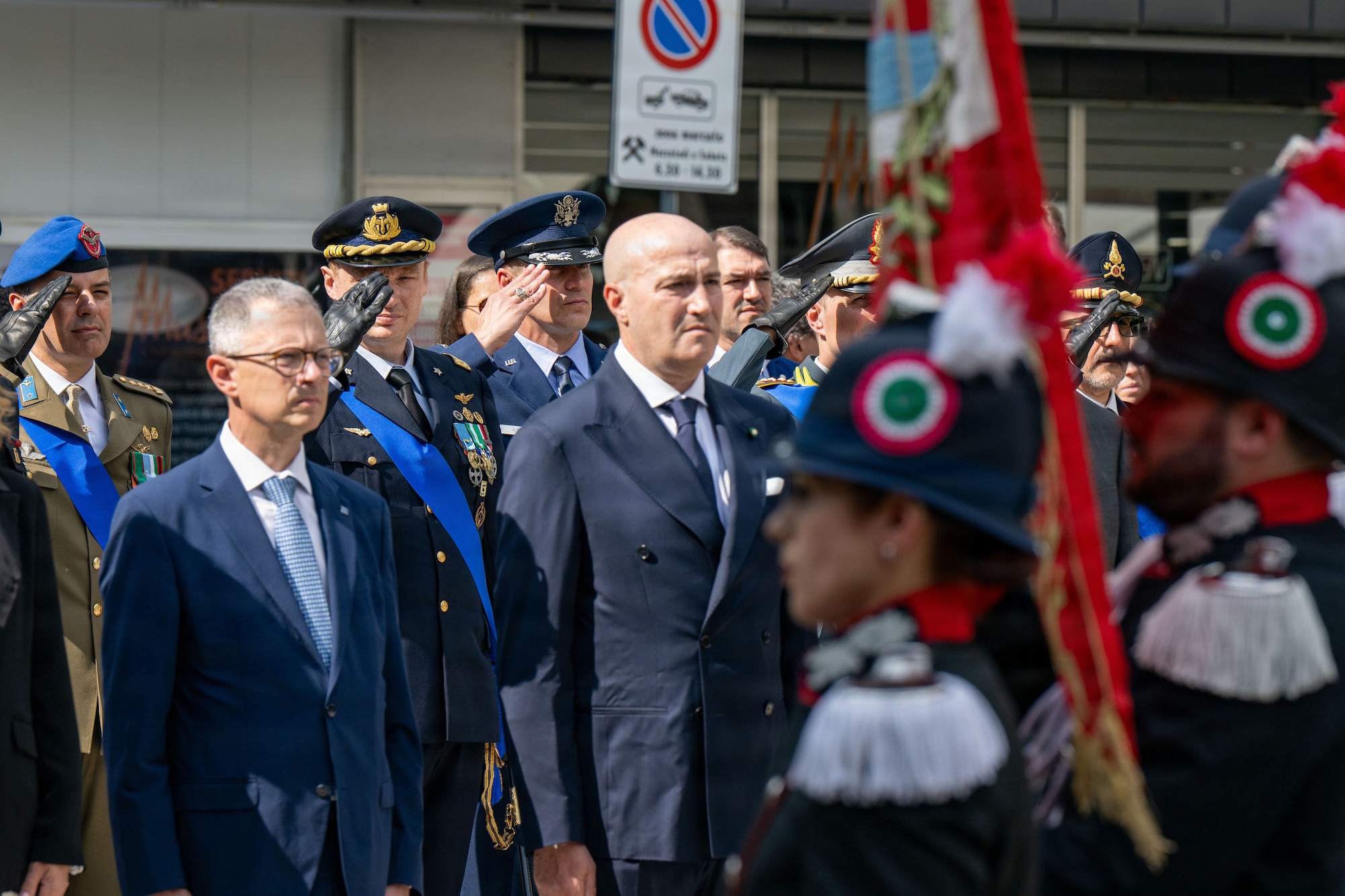 Men in military uniform stand together saluting