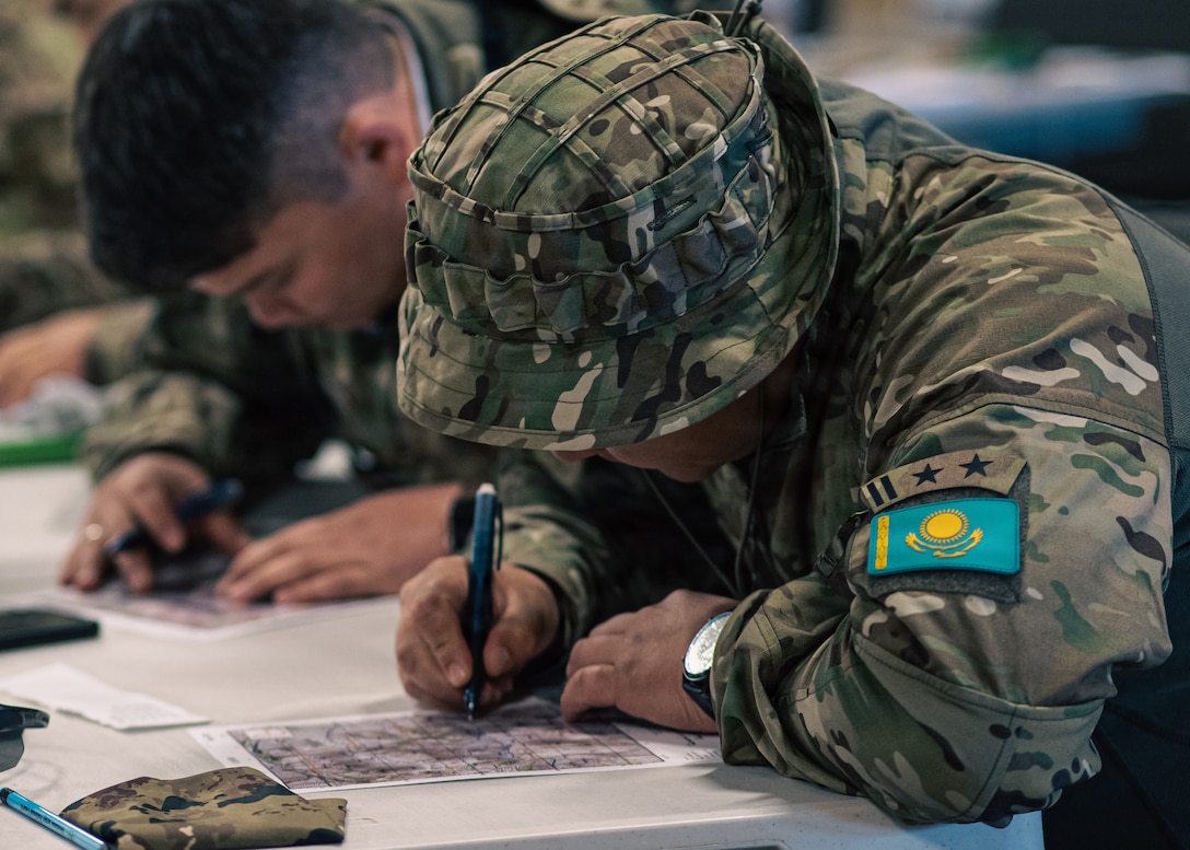 A Kazakhstani partner plots points on a map during land navigation training at Fort Harrison, Montana, June 2, 2026, as part of exercise Regional Cooperation 2026. Regional Cooperation 2026 is an annual, multinational U.S. Central Command-sponsored command-post, field training and cyber defense exercise conducted by U.S. National Guard units in partnership with nations from Central and South Asia, and other participating nations. (Oklahoma National Guard photo by Sgt. Anthony Ackah-Mensah)