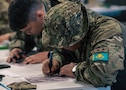 A Kazakhstani partner plots points on a map during land navigation training at Fort Harrison, Montana, June 2, 2026, as part of exercise Regional Cooperation 2026. Regional Cooperation 2026 is an annual, multinational U.S. Central Command-sponsored command-post, field training and cyber defense exercise conducted by U.S. National Guard units in partnership with nations from Central and South Asia, and other participating nations. (Oklahoma National Guard photo by Sgt. Anthony Ackah-Mensah)