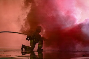A firefighter with the 19th Combat Air Base Squadron sprays water on a simulated engine fire during exercise Storm Flag 26-07 in Gulfport, Miss. May 13, 2026. The exercise provided a dynamic training environment where participants refined the skills, tactics and strategies needed to operate effectively in a complex battlefield environment. (U.S. Air Force photo by Senior Airman Isabella Ortega)