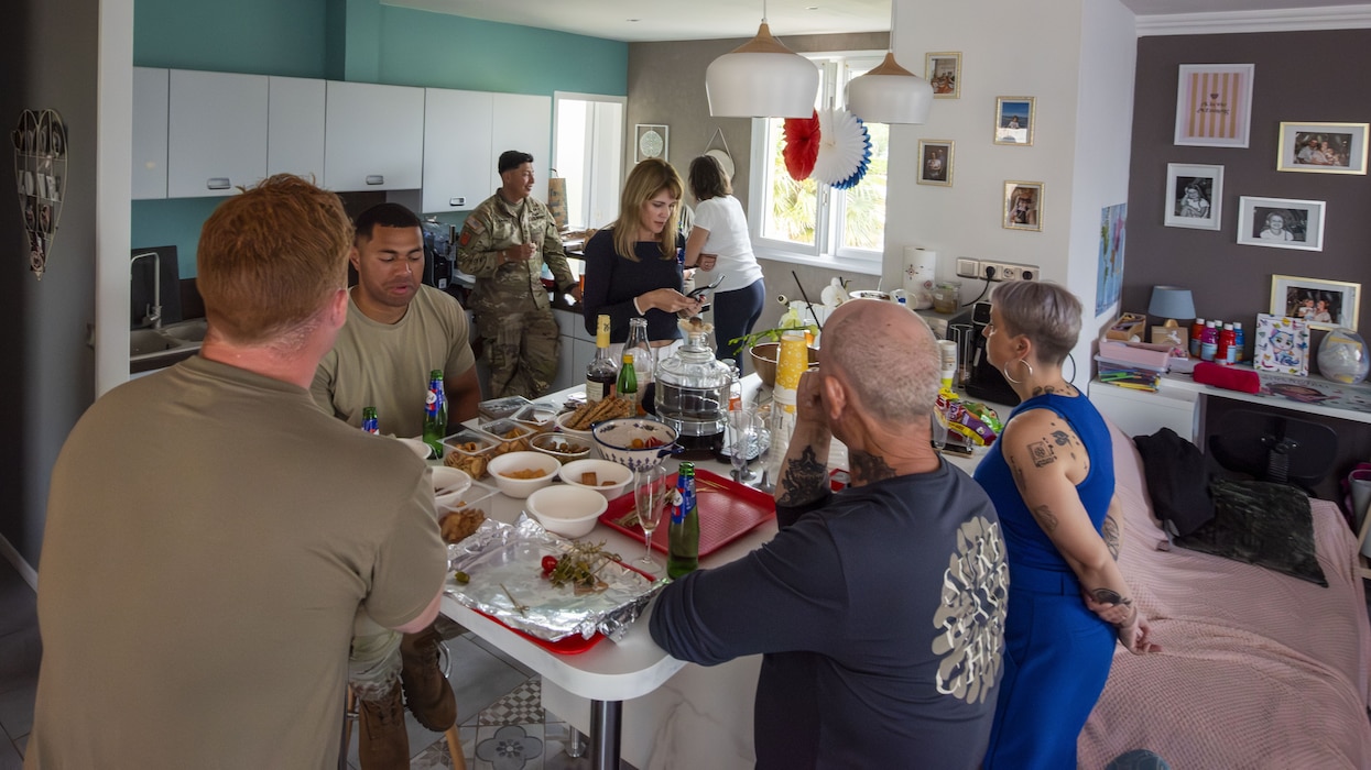 MEN AND WOMEN AROUND A DINNER TABLE