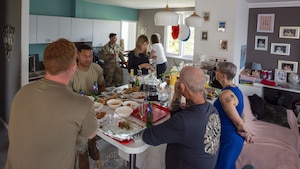 MEN AND WOMEN AROUND A DINNER TABLE