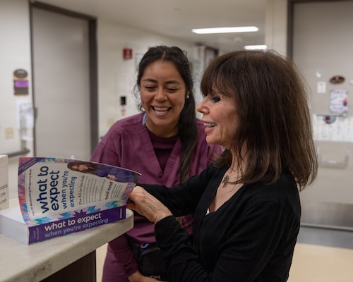 Author Heidi Murkoff signs a copy of her pregnancy guide, "What to Expect When You’re Expecting", for staff nurse Bianca Taylor, at Naval Medical Center San Diego, May 28. Murkoff visited NMCSD to boost morale by interacting with patients and staff. NMCSD employs more than 5,500 active-duty military personnel, civilians, and contractors in Southern California to deliver exceptional care afloat and ashore. (U.S. Navy photo by Mass Communication Specialist 3rd Class Jason Afable)