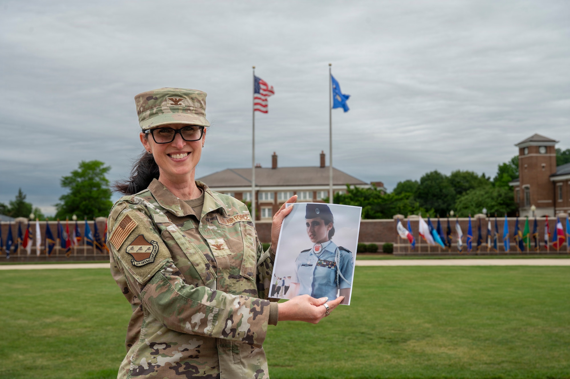 U.S. Air Force Col. Kelli R. Moon, commander of the 11th Operations Group at Joint Base Anacostia-Bolling, holds a photo of her younger self on the Ceremonial Lawn at JBAB, Washington, D.C. May 27, 2026. The photo depicts her as a 14-year old Air Force Junior Reserve Officer Training Corps cadet at Belton-Honea Path High School, Honea Path, South Carolina.  (U.S. Air Force photo by Senior Airman Shanel Toussaint)