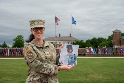U.S. Air Force Col. Kelli R. Moon, commander of the 11th Operations Group at Joint Base Anacostia-Bolling, holds a photo of her younger self on the Ceremonial Lawn at JBAB, Washington, D.C. May 27, 2026. The photo depicts her as a 14-year old Air Force Junior Reserve Officer Training Corps cadet at Belton-Honea Path High School, Honea Path, South Carolina.  (U.S. Air Force photo by Senior Airman Shanel Toussaint)