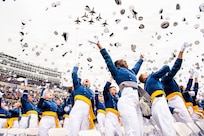 Graduating cadets from the U.S. Air Force Academy Class of 2026 toss their hats in the air as the U.S. Air Force Thunderbirds fly over Falcon Stadium in Colorado Springs, Colo., May 28, 2026. A total of 931 cadets received commissions as second lieutenants in the U.S. Air Force and U.S. Space Force. (U.S. Air Force photo by Adalyn Greene)