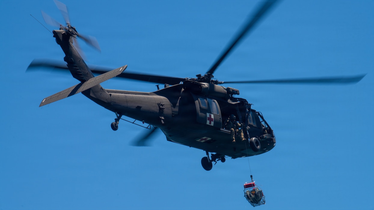 Helicopter hoists Airmen in rescue basket