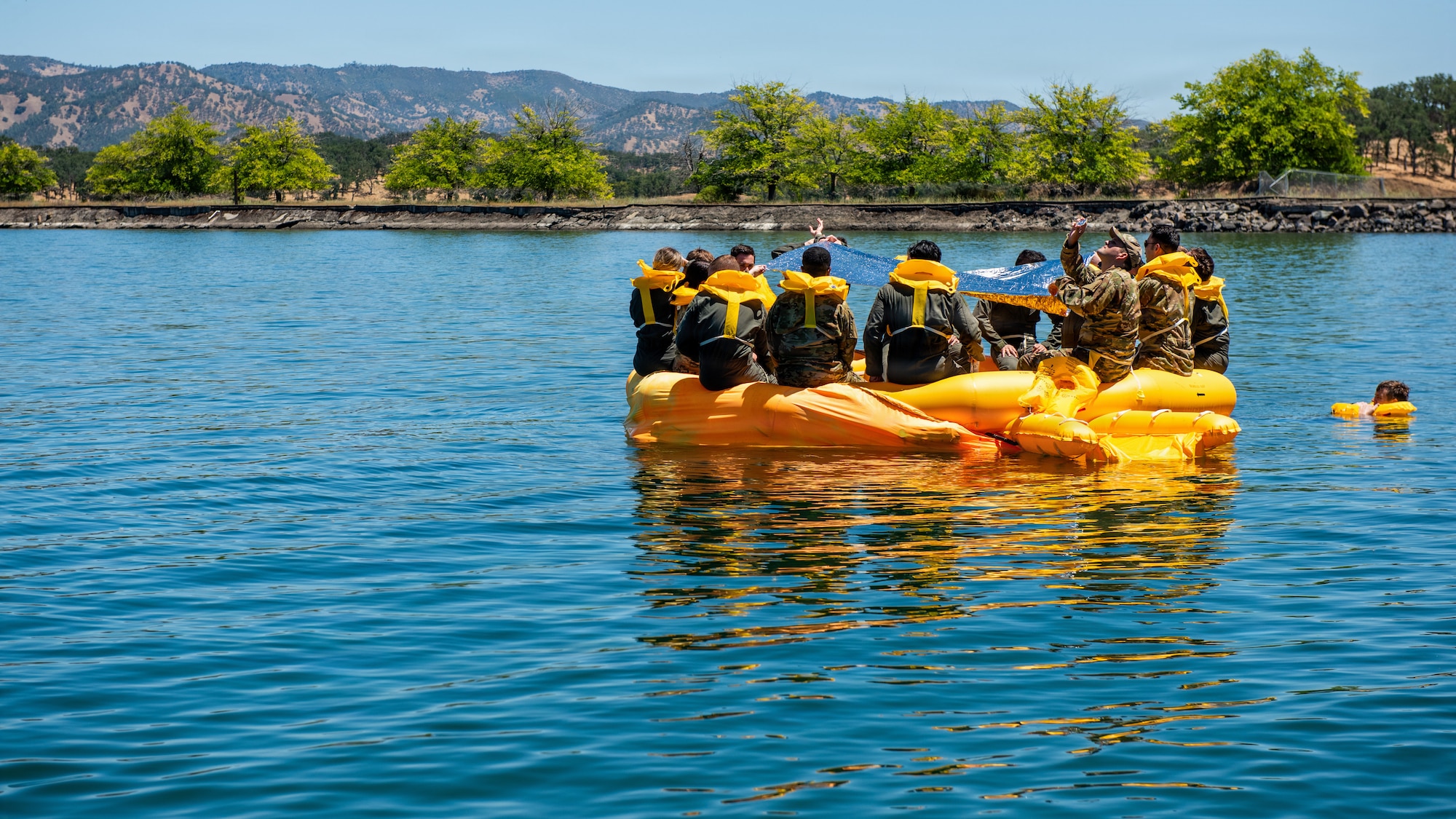 Airmen attempt to signal aircraft in a life raft