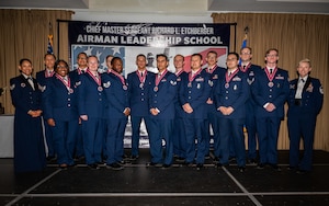 A photo of a group of people standing on a stage together.