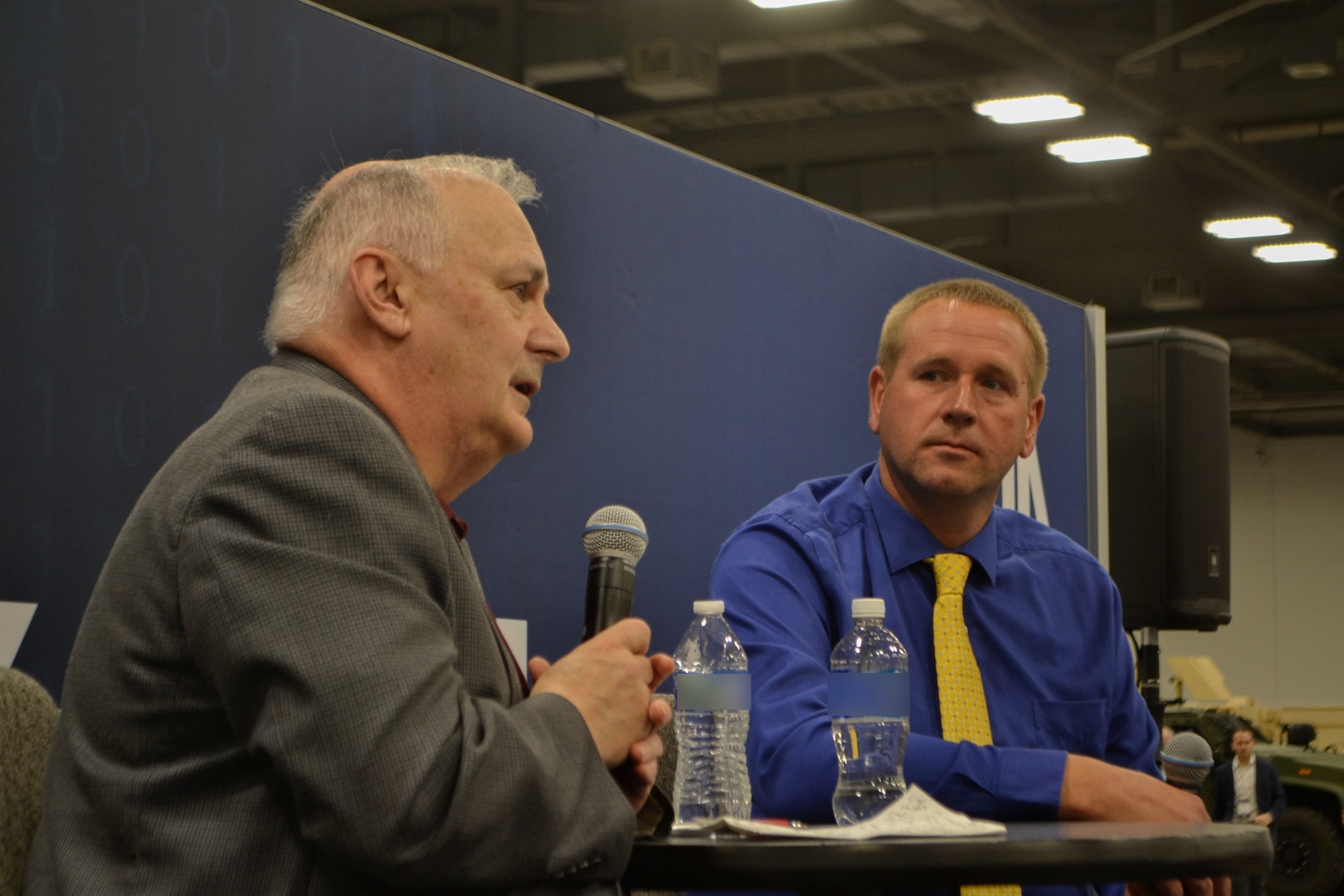 Bill Kenny, DLA Troop Support Executive Director of Contracting and Acquisition Management, and John Fafara, Director of Procurement, address attendees at the "knowledge bar" during the DLA Supply Chain Alliance Symposium & Exhibition in Columbus, Ohio, June 3, 2026. The leaders provided a command overview and answered questions on how to navigate the federal procurement process.