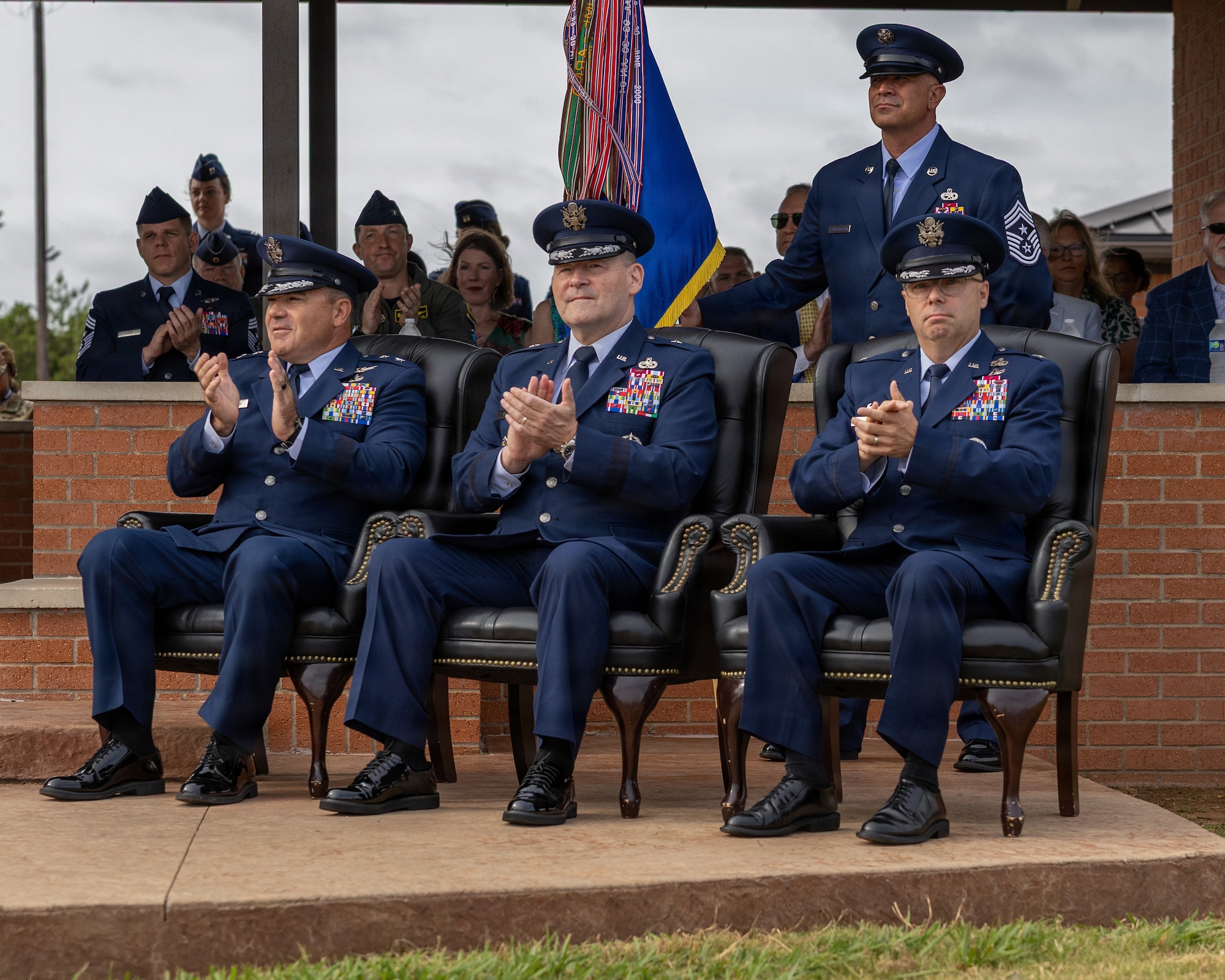 From left, U.S. Air Force Maj. Gen. Wolfe Davidson, Second Air Force commander; U.S. Air Force Brig. Gen. Paul Filcek, 82nd Training Wing and installation outgoing commander; and U.S. Air Force Col. Samuel Mink, 82nd TRW and installation incoming commander, clap during the 82nd TRW change of command ceremony at Sheppard Air Force Base, Texas, June 5, 2026.