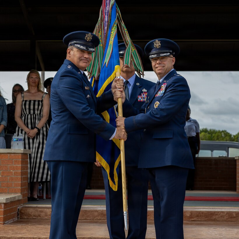 From left, U.S. Air Force Maj. Gen. Wolfe Davidson, Second Air Force commander, presents the guidon to U.S. Air Force Col. Samuel Mink, 82nd Training Wing and installation incoming commander, during the 82nd TRW change of command ceremony at Sheppard Air Force Base, Texas, June 5, 2026.