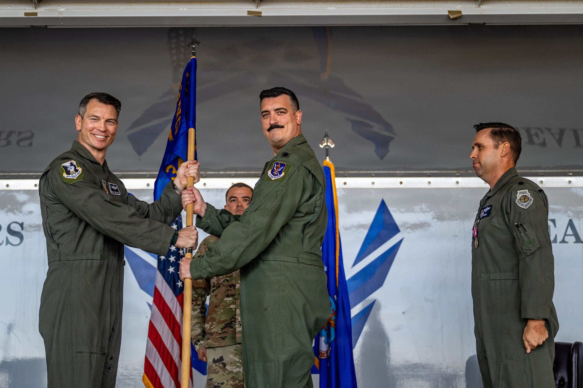 U.S. Air Force Col. Brian Desautels, 347th Rescue Group commander, passes the guidon to Lt. Col. Brendan de Brun, right, 71st Rescue Squadron commander, during a change of command ceremony at Moody Air Force Base, Georgia, June 5, 2026.