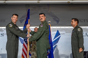 U.S. Air Force Col. Brian Desautels, 347th Rescue Group commander, passes the guidon to Lt. Col. Brendan de Brun, right, 71st Rescue Squadron commander, during a change of command ceremony at Moody Air Force Base, Georgia, June 5, 2026.