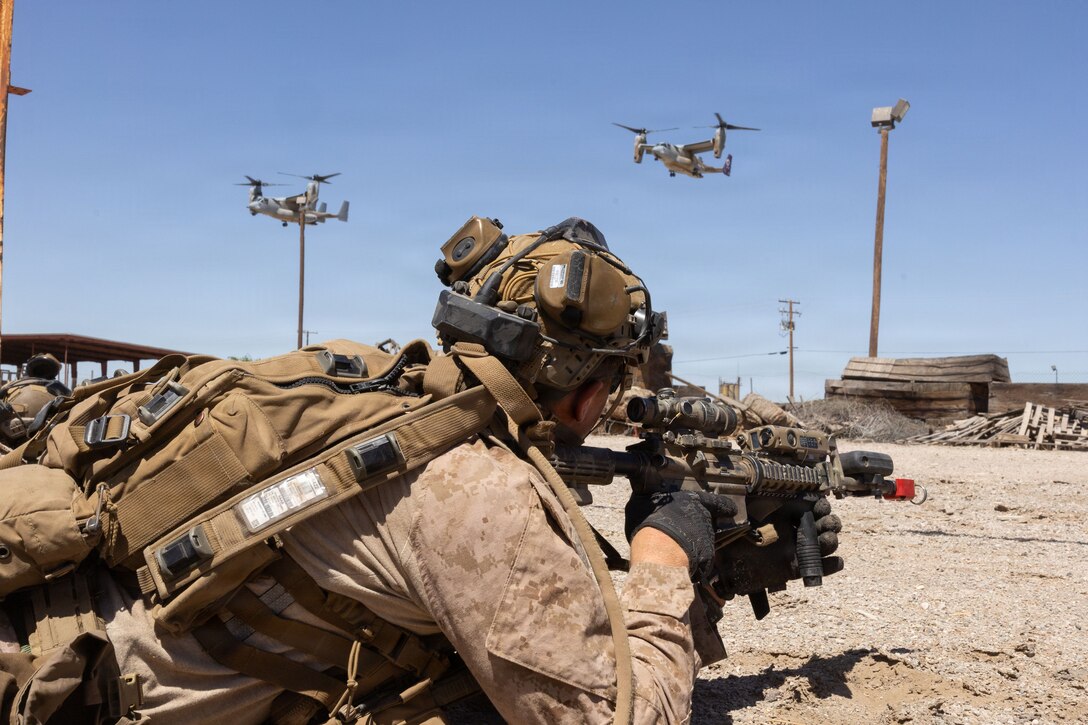 A U.S. Marine assigned to Battalion Landing Team 2/4, 13th Marine Expeditionary Unit, provides security as MV-22B Ospreys prepare to land after conducting a simulated raid during Realistic Urban Training at Blythe, California, May 31, 2026. RUT is a critical pre-deployment exercise that enables the 13th MEU to integrate its command, aviation, ground and logistics combat elements, ensuring the force is prepared to respond rapidly and effectively to crises in unfamiliar, urban environments. (U.S. Marine Corps photo by Lance Cpl. Christian Cutter)
