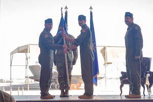 U.S. Air Force Col. Oliver Lause, 56th Operations Group commander, passes the guidon to Lt. Col. Adam Peterson, incoming 63rd Fighter Squadron commander, at Luke Air Force Base, Arizona, June 5, 2026.