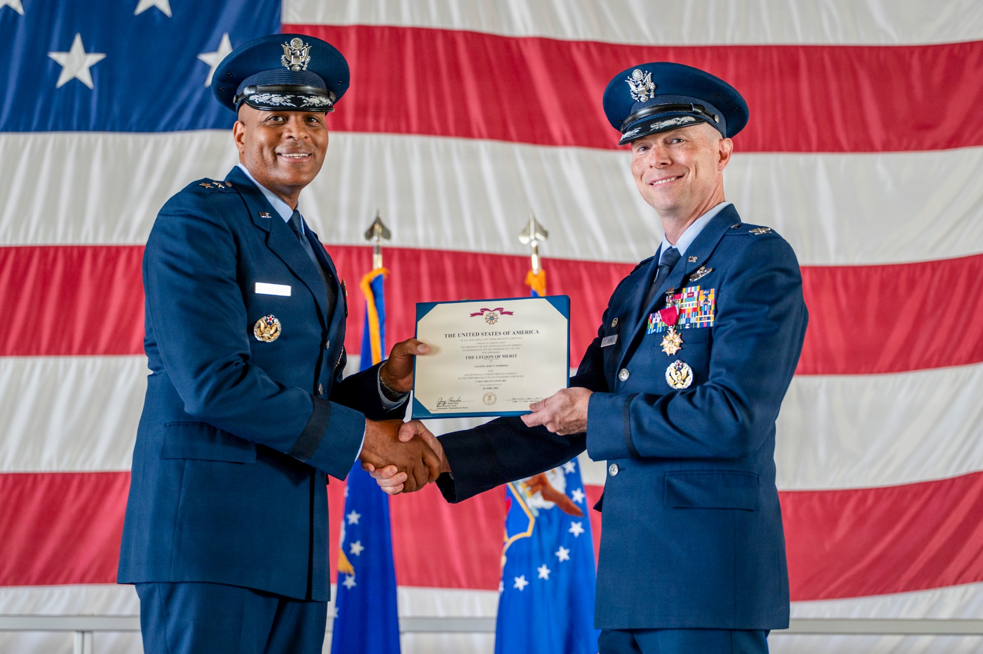U.S. Air Force Col. John Ethridge, 49th Wing commander, right, receives the Legion of Merit award from Maj. Gen. Roy W. Collins, Air Education and Training Command deputy commander, during a change of command ceremony at Holloman Air Force Base, New Mexico, June 4, 2026. The Legion of Merit is a distinguished U.S. military award presented for exceptionally meritorious conduct and outstanding service in key positions of responsibility, uniquely conferred upon both American service members and foreign military or civilian personnel. (U.S. Air Force photo by Senior Airman Michelle Ferrari)