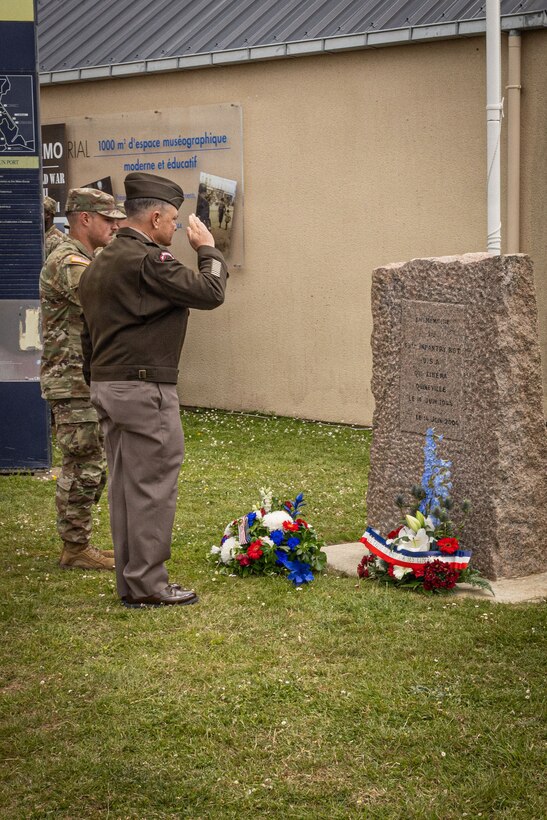 Maj. Gen. Patrick Ellis, commanding general of the 4th Infantry Division, and Spc. Rylee Parker, assigned to the  299th Brigade Engineer Battalion, 1st Stryker Brigade Combat Team, 4ID, pays honors during a D-Day 82 Memorial Ceremony, Quinéville, Normandy, June 05, 2026. The event memorialized the sacrifices of 4th Infantry Division Soldiers during the D-Day landings to liberate Europe from Nazi occupation. (U.S. Army photo by Sgt. William Rogers)