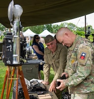 Command Sgt. Maj. Christopher Prosser, First Army, observes historic camera alongside historic reenactors at Chateau Voilly, the original World War II Headquarters for the U.S. Army Press Camp in Normandy, France, on June 2, 2026, during D-Day 82 Ceremonies.
