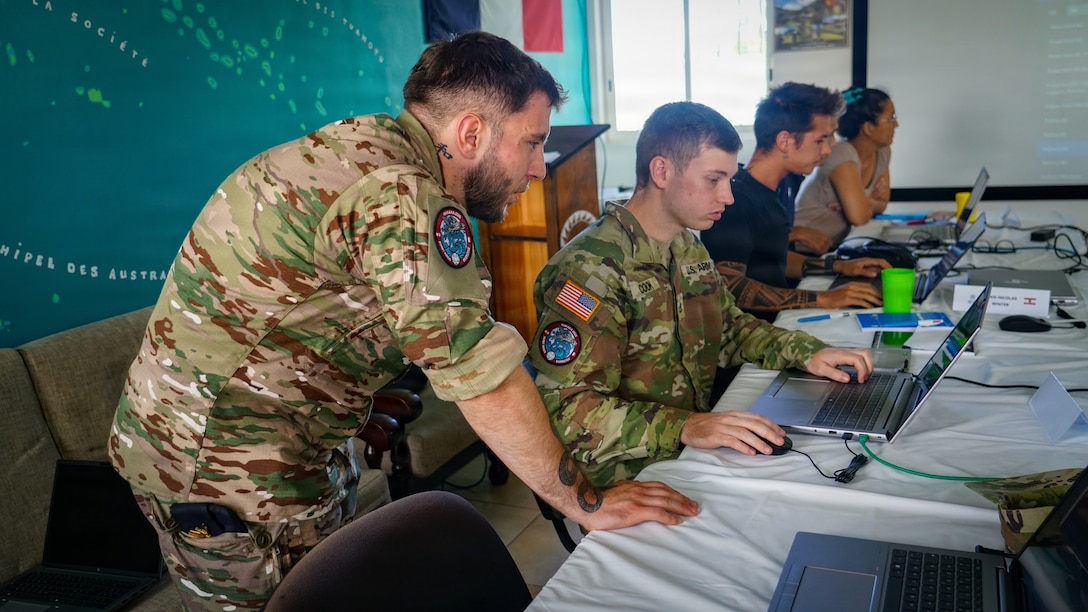 French Army Sgt. Erwan, assigned to the Army Forces in French Polynesia (FAPF) and Staff Sgt. Lawrence Cook, a cyber operations specialist assigned to 1st theater Information Advantage Detachment, work together during the cyber awareness challenge.