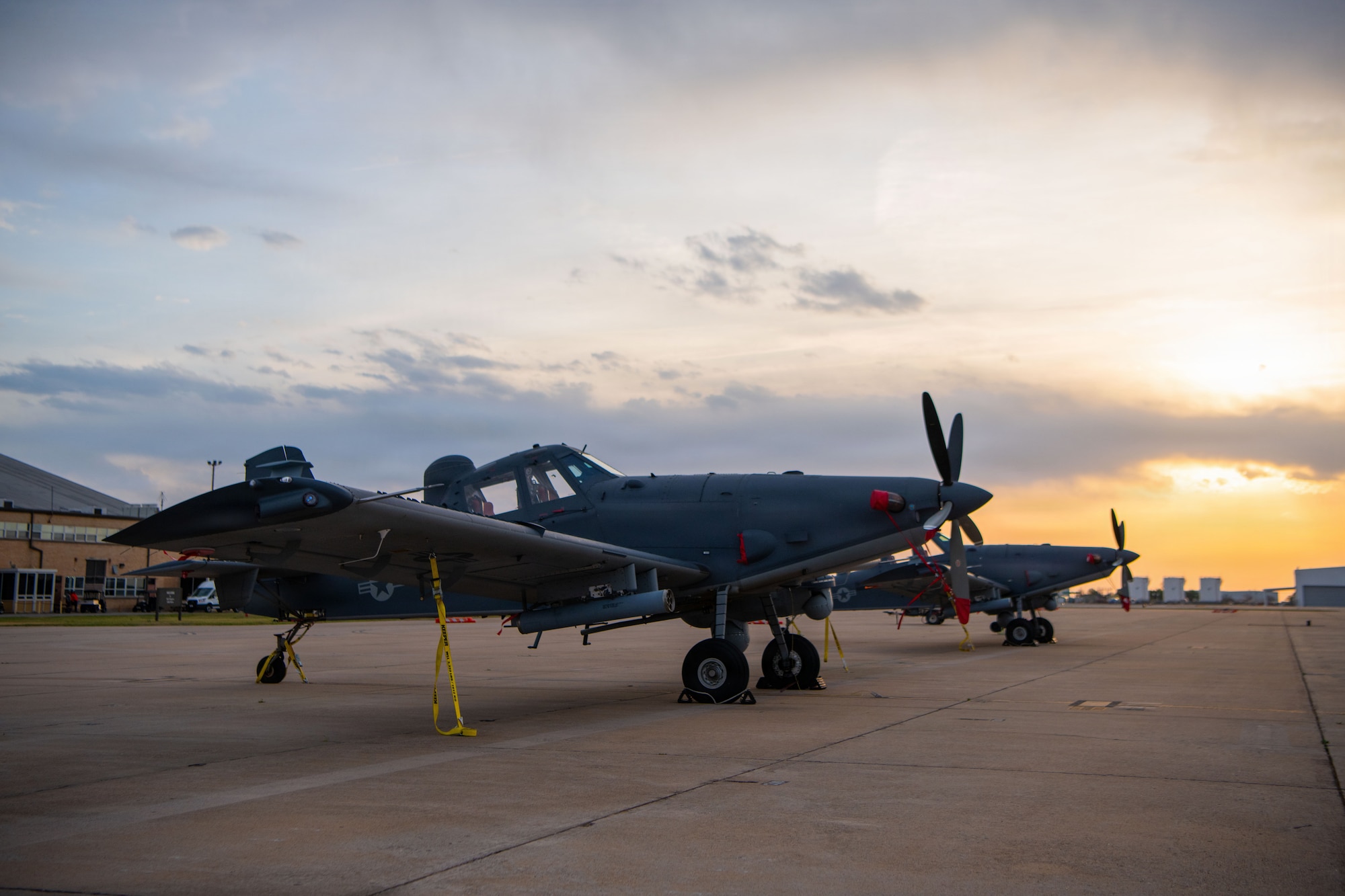 A military aircraft sits on the flightline.