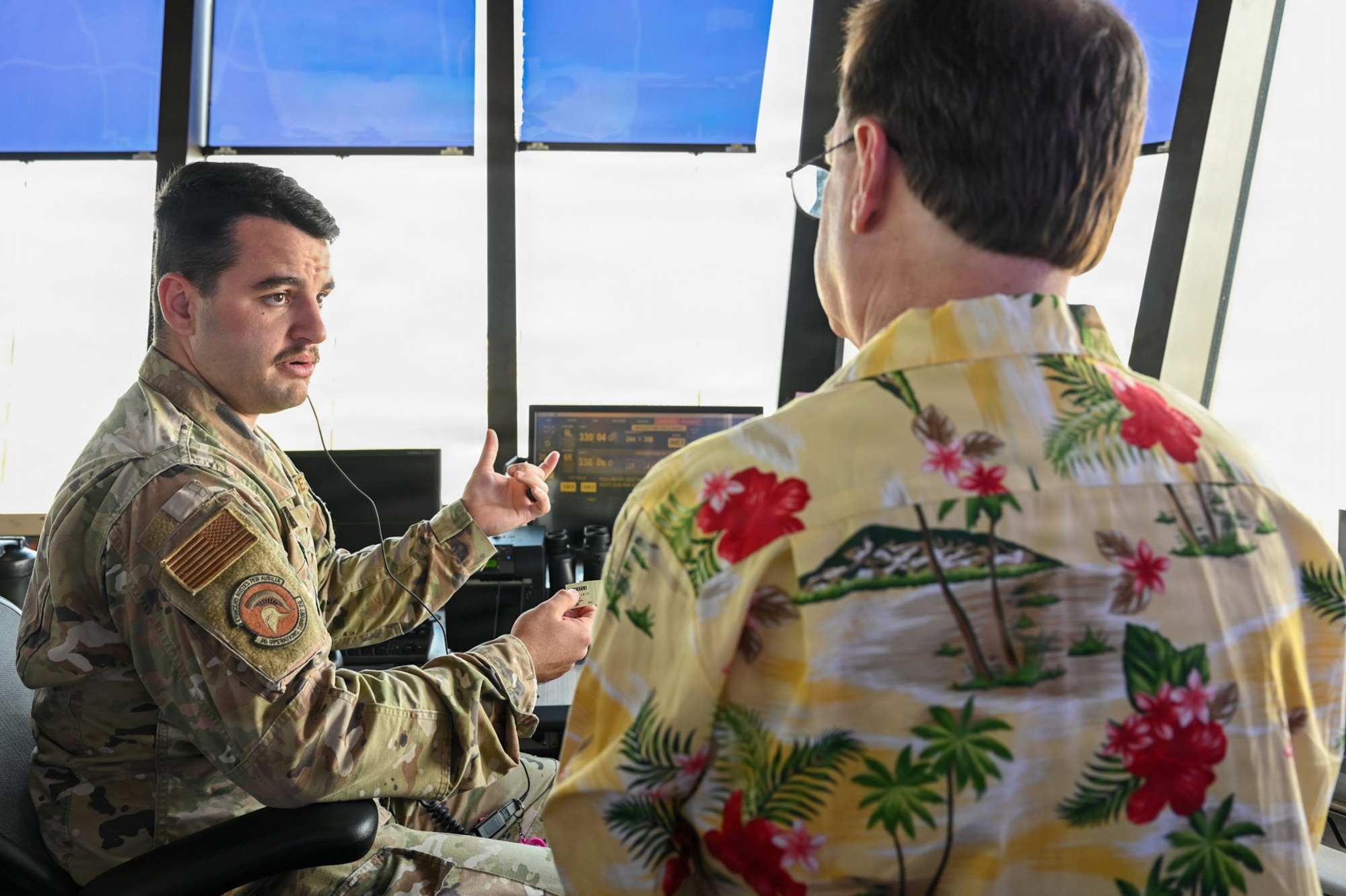 U.S. Air Force Senior Airman Robert Rennie, 36th Operations Support Squadron air traffic control tower specialist, discusses air traffic control operations with Dr. Glenn Antizzo, an instructor with Mississippi College.