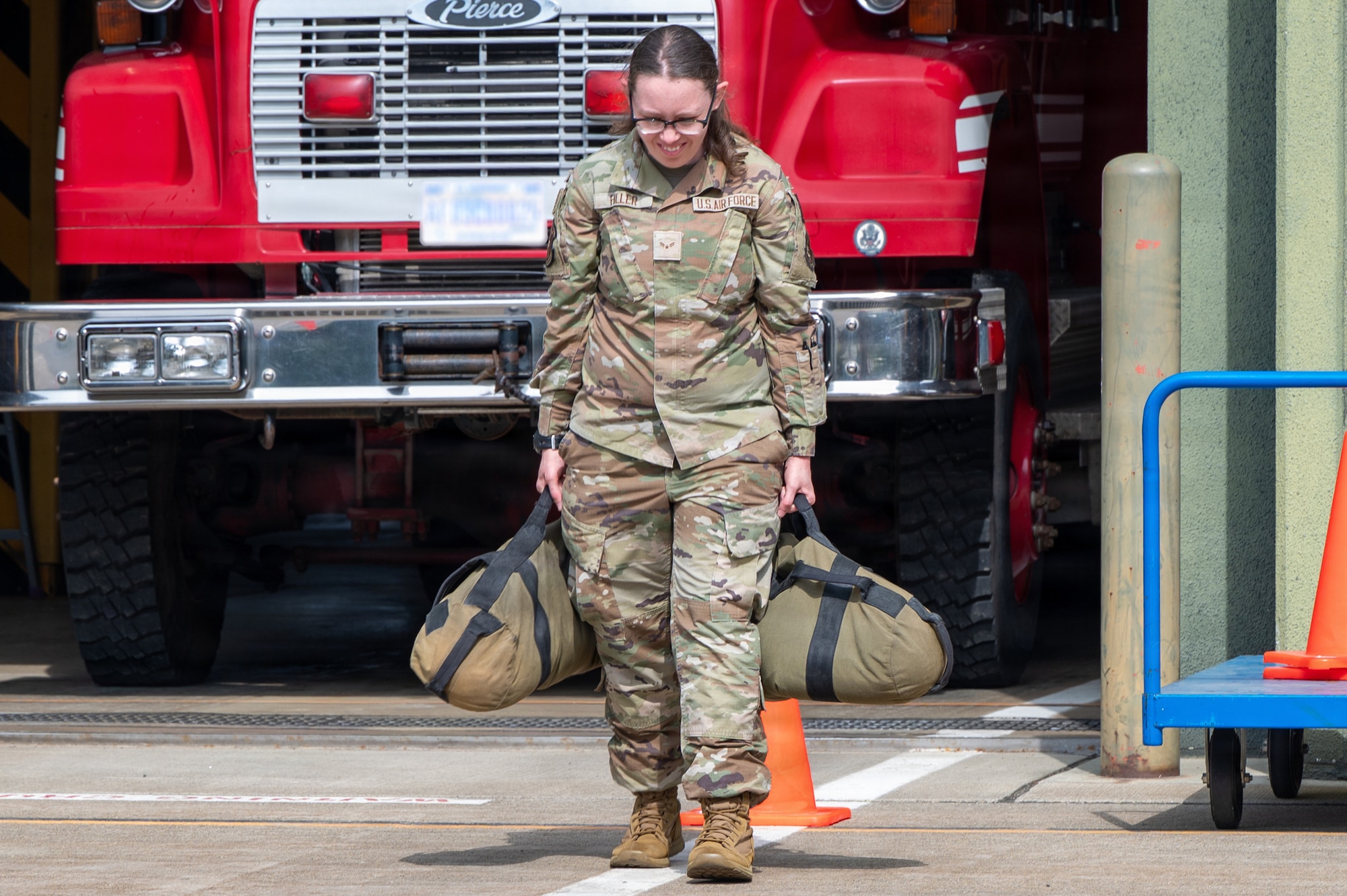 U.S. Air Force Airman 1st Class Sara Fuller, 35th Medical Group patient administration specialist, carries weighted bags during a firefighter challenge as part of the Wild Weasel immersion tour
