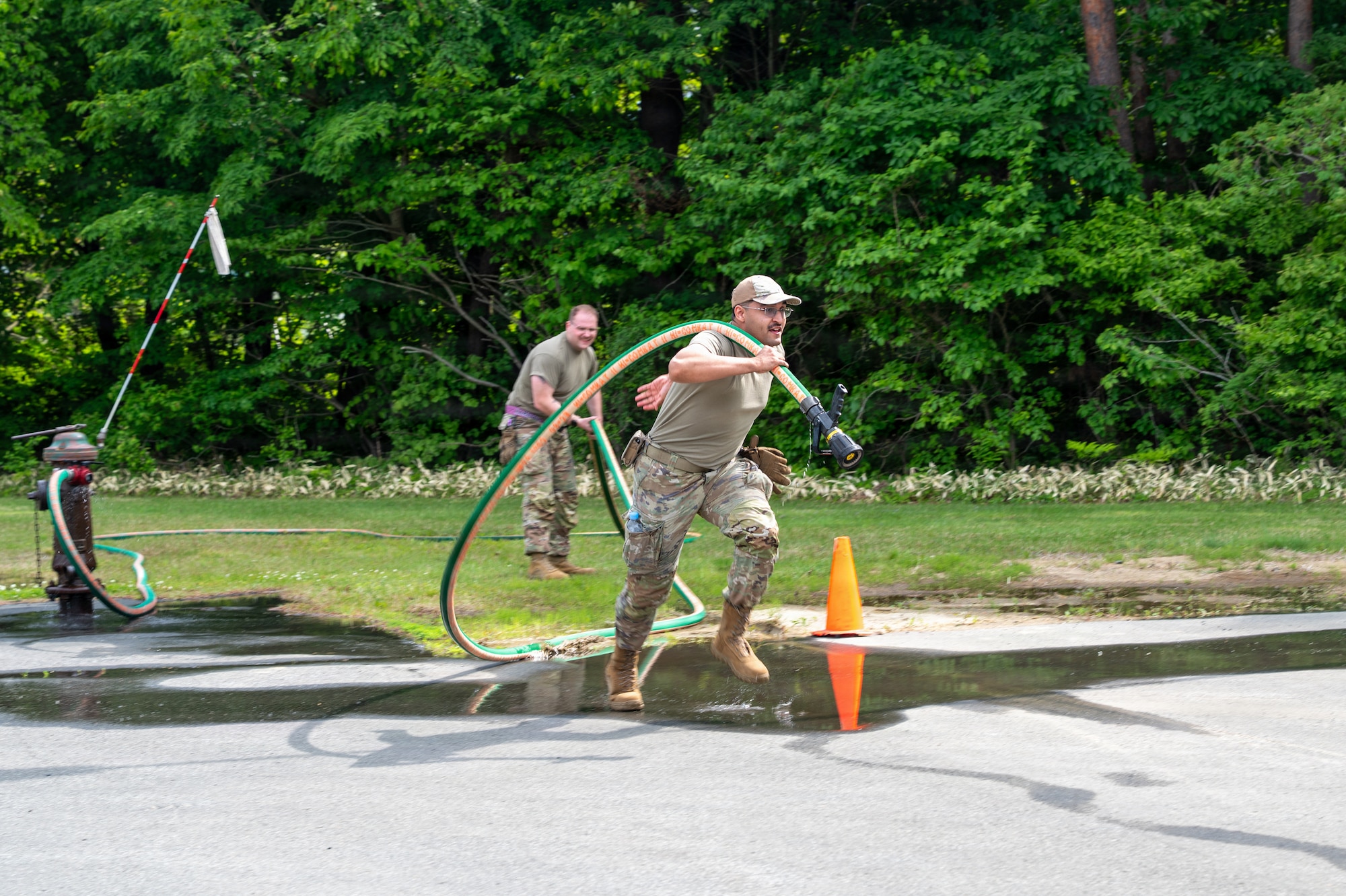 U.S. Air Force Senior Airman Tyrese Jones, 35th Logistics Readiness Squadron vehicle operator, participates in a firehose carry during a firefighter challenge as part of the Wild Weasel immersion tour