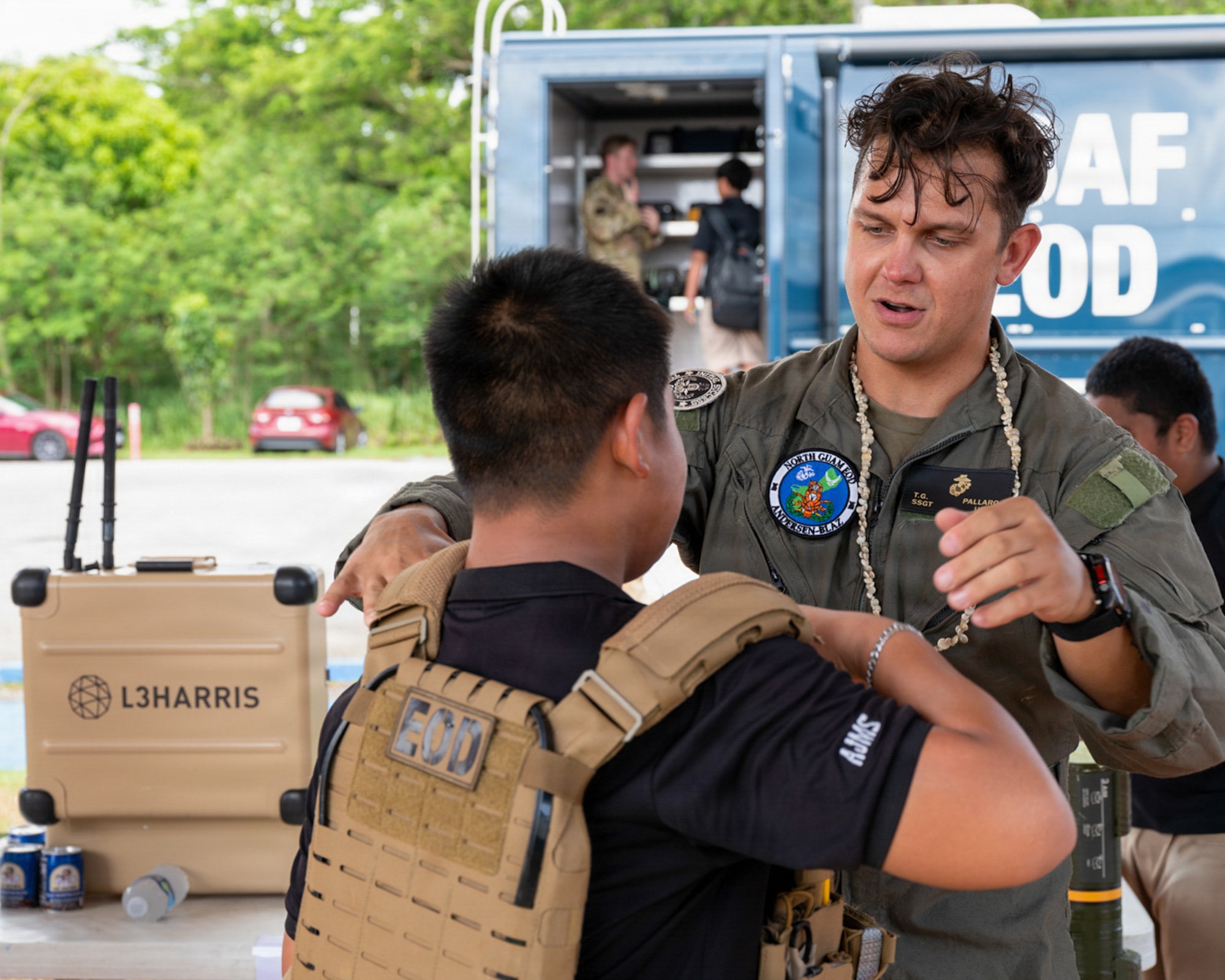U.S. Marine Corps Staff Sgt. Tommaso Pallaro, explosive ordnance disposal technician out of Marine Corps Base Camp Blaz, Guam, helps a student try on a plate carrier.