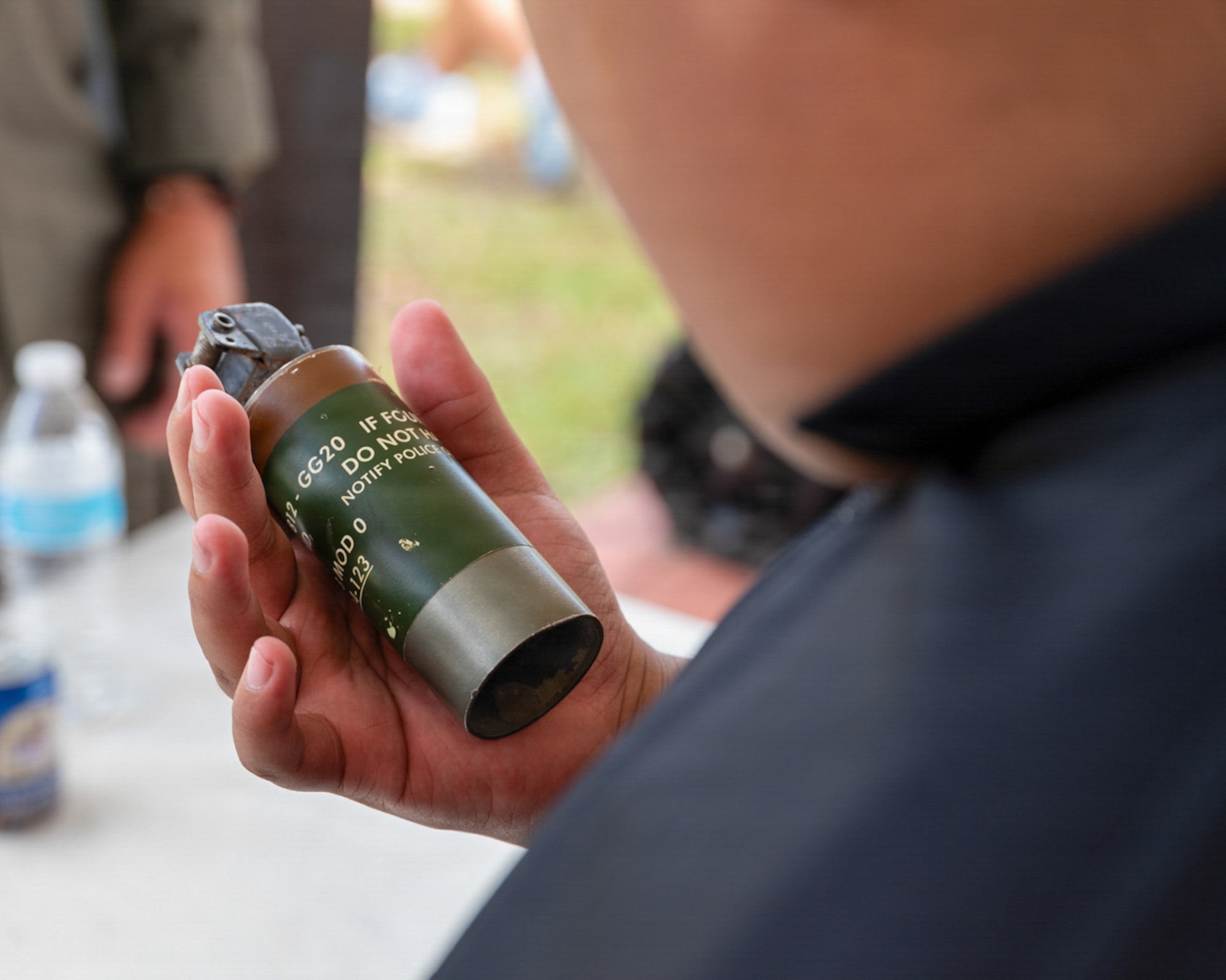 A middle school student observes a deactivated stun grenade during a career day event with Team Andersen's explosive ordnance disposal team.