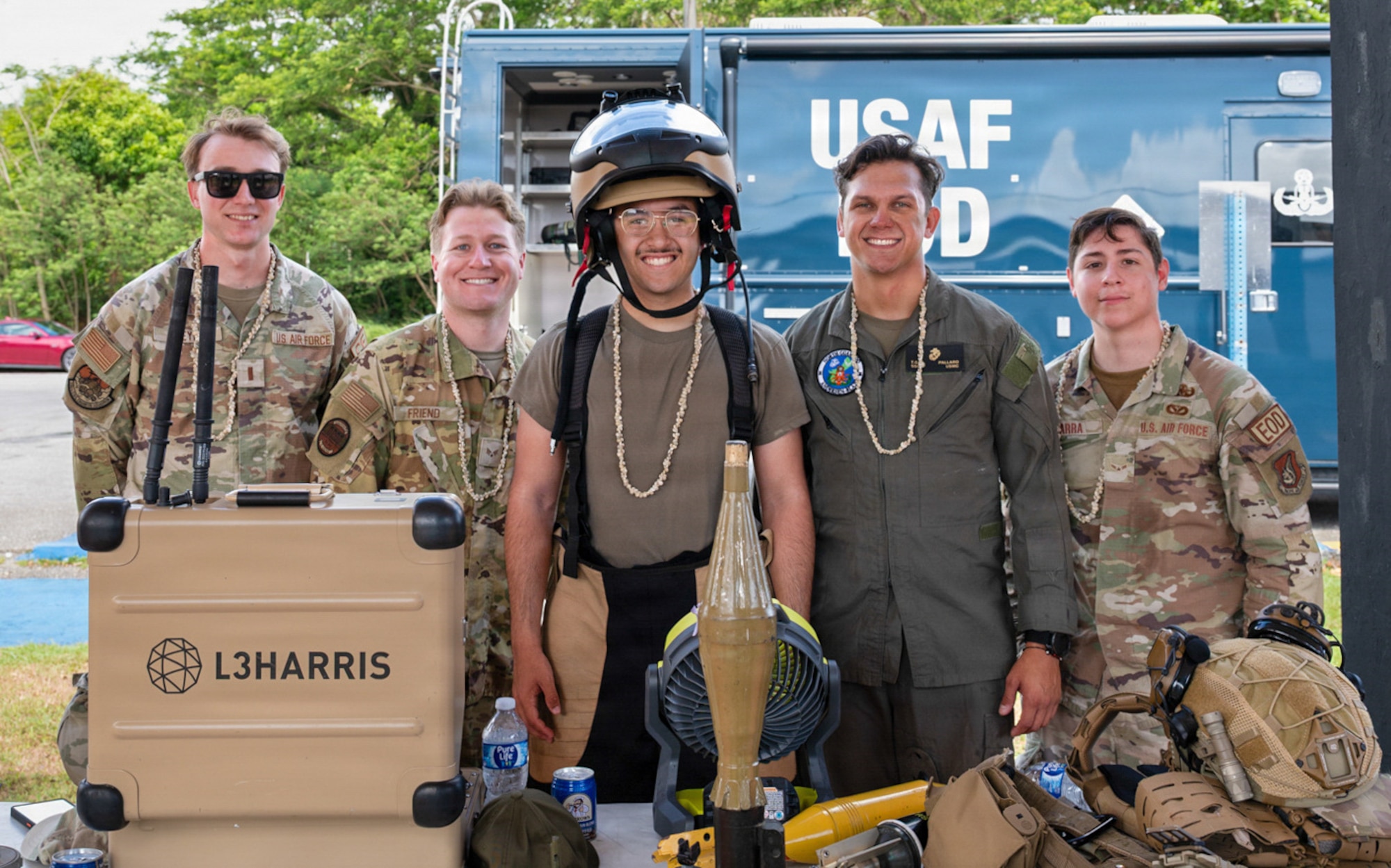 U.S. Airmen and Marines, representing Team Andersen’s explosive ordnance disposal team, stand for a group photo at a career day event.