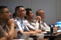 U.S. Air Force Col. David Bargatze, U.S. Forces Japan staff judge advocate, with representatives from the Tri-Command Judge Advocate’s Office and Japan Ground Self-Defense Force listen during a briefing at the 2026 Northeast Asia International and Operational Law Conference May 19, 2026 at the New Sanno Hotel in Tokyo, Japan.