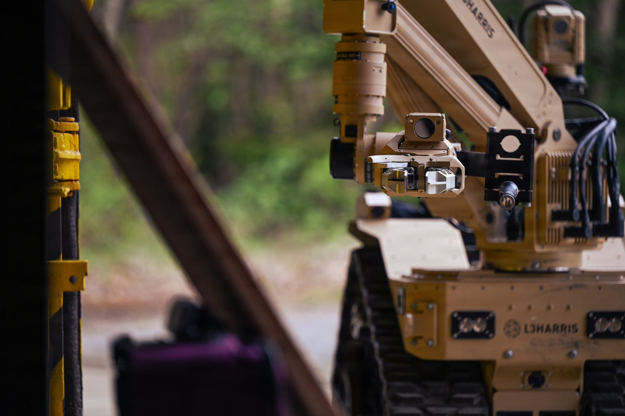 A U.S. Air Force L3 Harris T7 Robotic System reaches for a simulated improvised explosive device