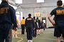 U.S. Sailors with Naval Support Activity Washington (NSAW) stand in formation before beginning a warm-up routine at the Washington Navy Yard, Washington, D.C.