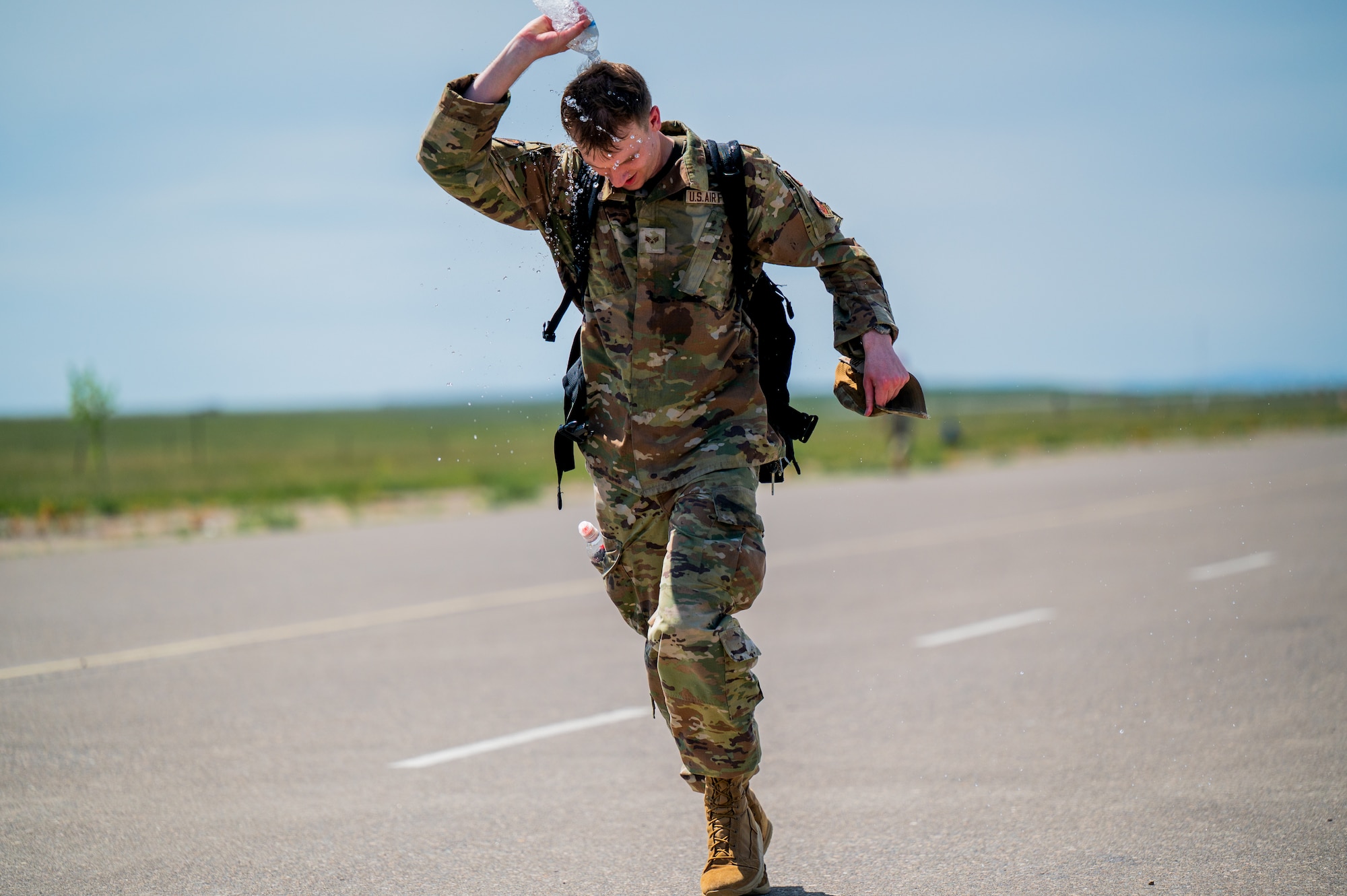 A participant in a Norwegian Foot March dumps water over his head as he approaches the finish line at Malmstrom Air Force Base, Montana, May 26, 2026.