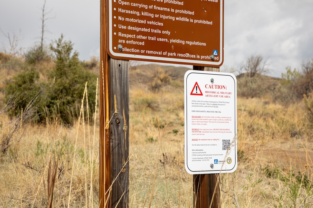 A sign warns visitors of potential munitions debris at William F. Hayden Park in Lakewood, Colorado, April 29, 2026. Historic Camp George West, approximately 2 miles north of the former Camp George West Artillery Range, was established in 1903 by the Colorado Army National Guard for small arms and artillery training. Green Mountain was used as a live-fire artillery impact area between 1903 and 1939. The U.S. Army Corps of Engineers, the Army National Guard, the Colorado Department of Public Health and Environment and the City of Lakewood have been working to remediate the site since 2010. (U.S. Army photo by Makenzie Leonard)