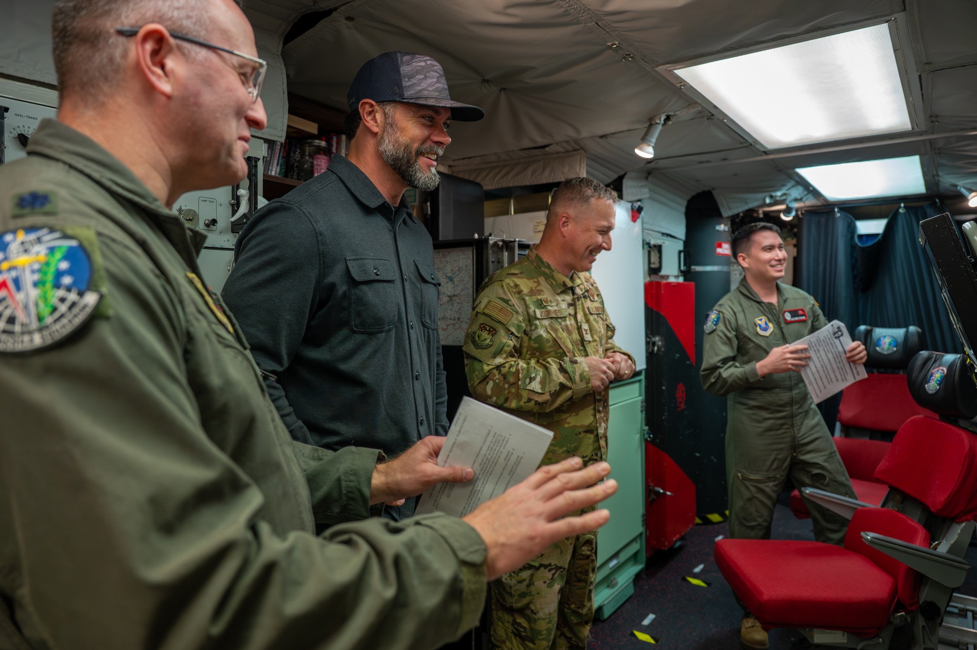 The Under Secretary of the Air Force and a group of military personnel stands in a launch control center.