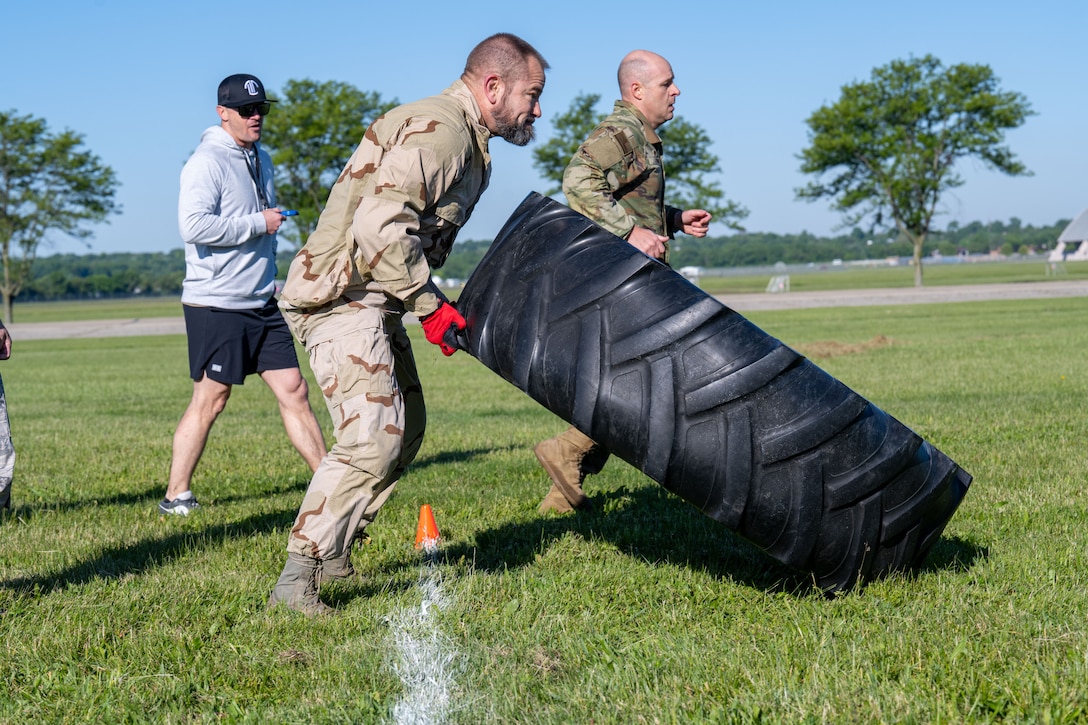 Two men wearing military attire compete in an obstacle course