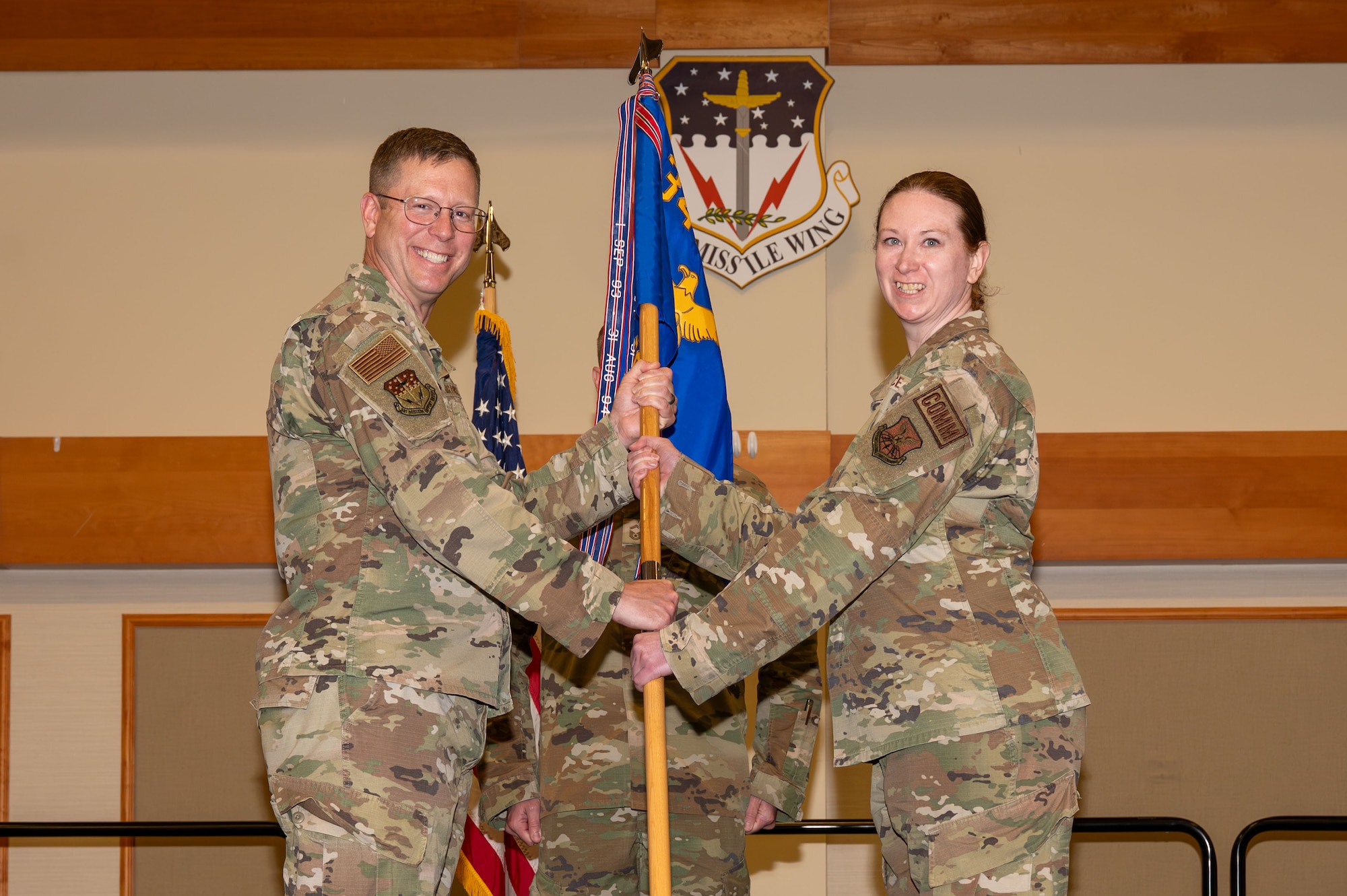 U.S. Air Force Lt. Col. Danielle Shipman, right, accepts command of the 341st Communications Squadron from Col. Brian Low, 341st Mission Support Group commander, during a change of command ceremony at Malmstrom Air Force Base, Montana, June 4, 2026. The 341st CS plans, operates and maintains information technology resources supporting the wartime requirements of Twentieth Air Force, the 341st Missile Wing and tenant units. (U.S. Air Force photo by Airman 1st Class Ethan Wilson)