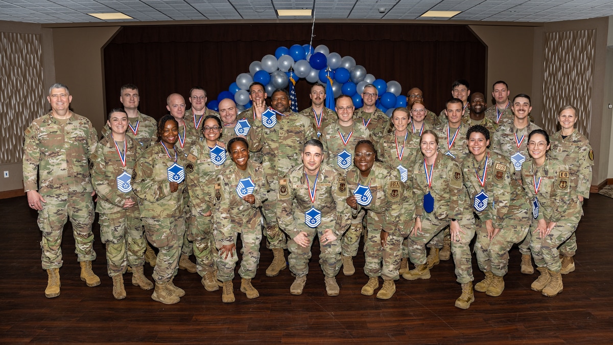 A group photo of men and women, wearing military camouflage uniforms, most wearing blue and white MSgt lanyards