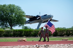 U.S. Airmen from the 17th Security Forces Squadron carry the American flag to begin the 24-hour flag movement during National Police Week at Goodfellow Air Force Base, Texas, May 12, 2026. The continuous relay served as a tribute to fallen law enforcement officers and Defenders, ensuring the colors remained in motion throughout the 24-hour observance. (U.S. Air Force photo by Senior Airman James Salellas)
