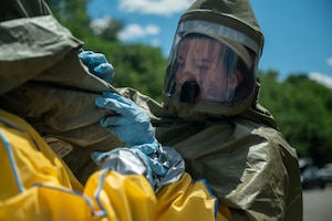 An Airman checks another Airman's hazmat suit.