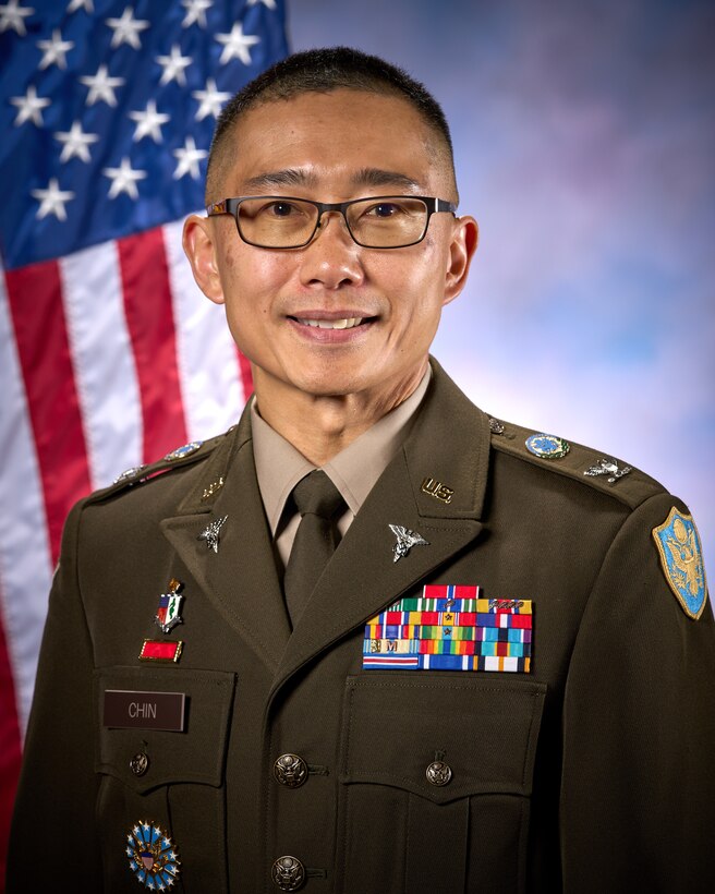 Smiling man wears glasses and an Army uniform